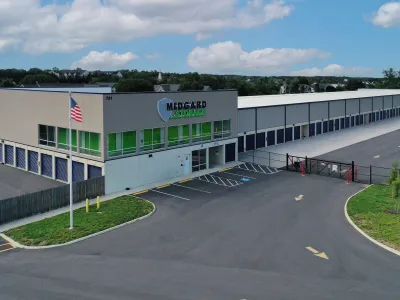 Modern Medgard Storage facility with multiple storage units and American flag under a partly cloudy sky
