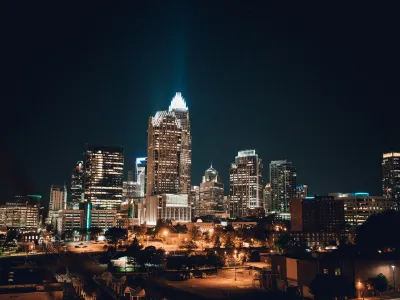 Night view of Charlotte skyline with illuminated skyscrapers and vibrant urban atmosphere.