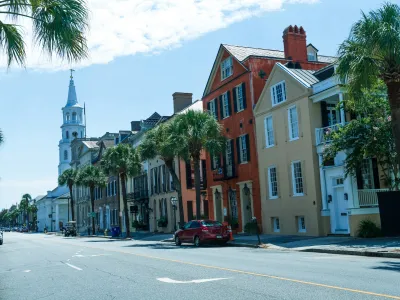 Charming street view of historic buildings lined with palm trees in Charleston, South Carolina.