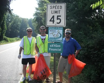 a group of people holding a sign posing for the camera