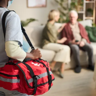 Person entering code on a white security alarm keypad mounted on a wall for home protection.