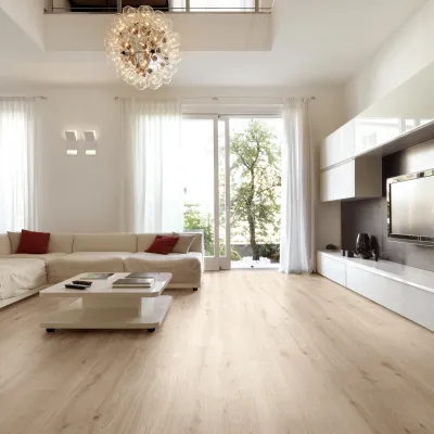 Bright modern living room with white sectional sofa, coffee table, large windows, and minimalist decor.