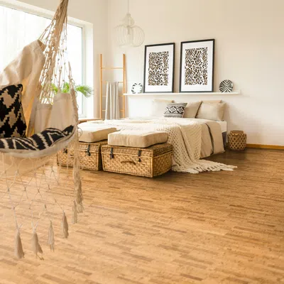 Cozy boho bedroom with woven baskets, hammock chair, neutral bedding, wooden floor, and leopard print wall art.