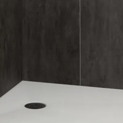Minimalist white shower base with black drain and dark textured wall tiles in a modern bathroom.