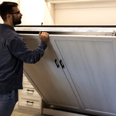 a man opening a wall bed or murphy bed