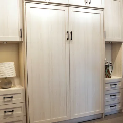 Elegant, modern storage cabinet with bedside lamp and decorative vase in a light-toned interior.