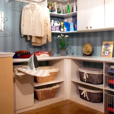 a white shelving unit with a basket and a basket of clothes