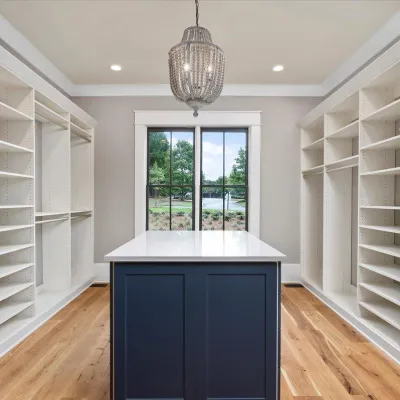 a room with white shelves and a white bathtub