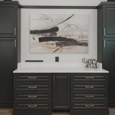 Home bar with black built-in cabinets, drawers, white counter top and abstract art