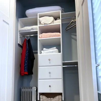 a small guest closet with shelving and long hang storage