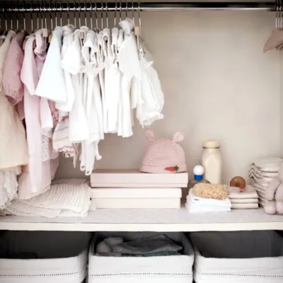 a child's closet with clothes, diapers, and stuffed animals