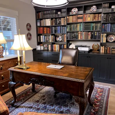 a room with a desk and bookshelves