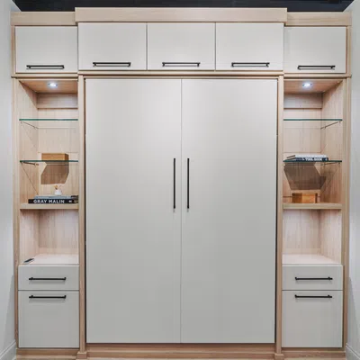 Modern wooden wall unit with white cabinets, glass shelves, and black handles in a well-lit room.