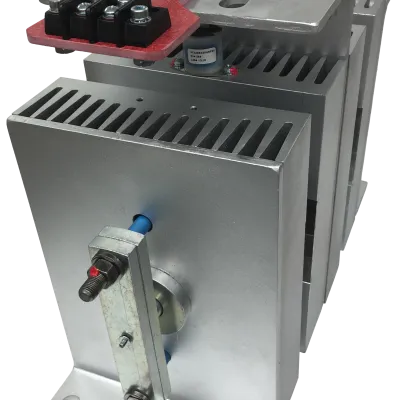 Silver industrial electrical component with heat sink fins and red terminal connectors for DC power.