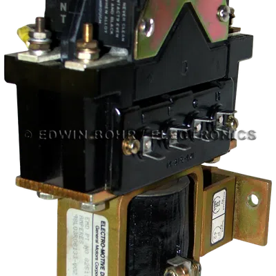 Black and gold General Motors Electro-Motive relay with front label and metal mounting bracket.