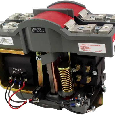 Close-up of an industrial electrical relay with visible wiring, coils, and metal contacts on a gray base.