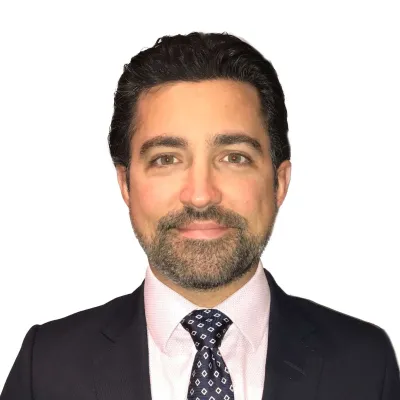 a man wearing a suit and tie smiling at the camera