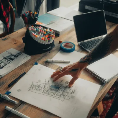 a desk with a laptop and a pen on it