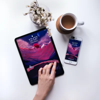 a hand holding a tablet and a cup of coffee