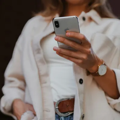 a person in a white coat holding a cell phone