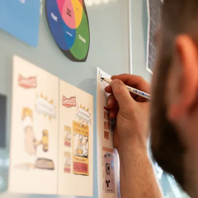 a person writing on a white board