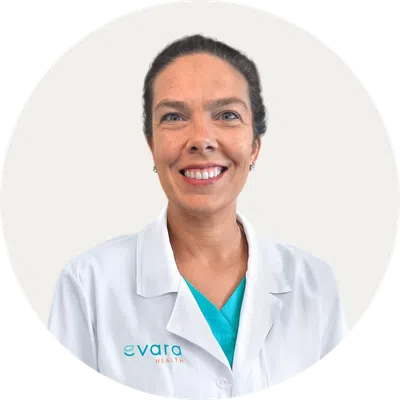 Smiling female healthcare professional wearing a white coat with Evara Health logo on light background