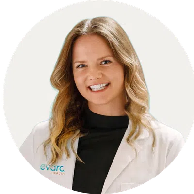 Smiling female healthcare professional wearing a white coat with Evora Health logo on a white background