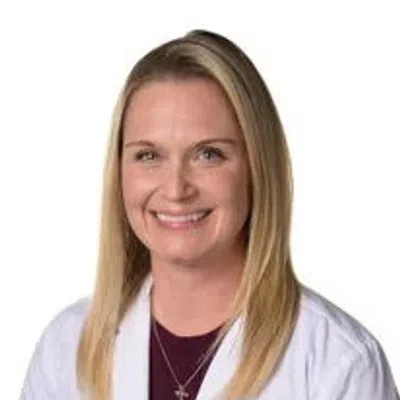 Smiling female healthcare professional in white lab coat with Evora Health logo on white background.