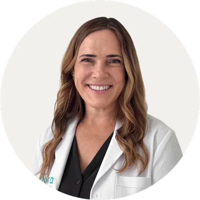 Smiling female doctor with long hair wearing a white lab coat and black shirt on a white background