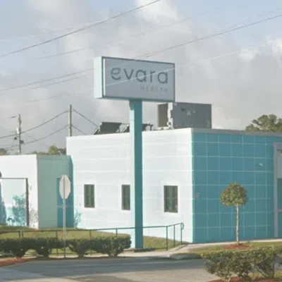 Evara Health medical clinic building with white and blue exterior and outdoor signage on a clear day.