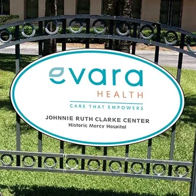 Evara Health sign at Johnnie Ruth Clarke Center outside Historic Mercy Hospital on a sunny day.