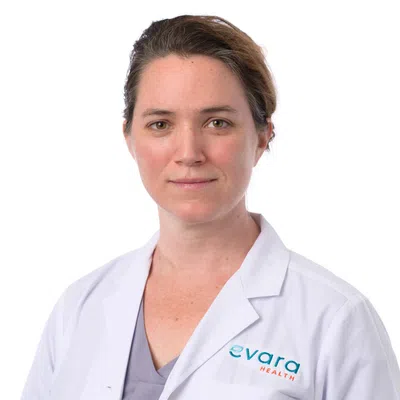 Portrait of a female healthcare professional in a white lab coat with Evara Health logo on a white background