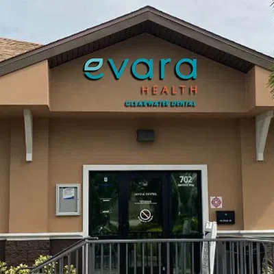 Exterior view of Evara Health Charlotte Dental clinic with signage and entrance door under cloudy sky