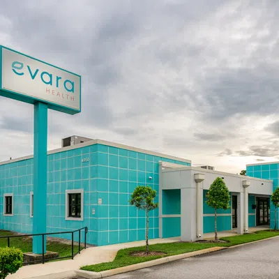 Evara Health medical office building with teal and white exterior under a cloudy sky.