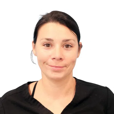 Smiling woman with dark hair wearing a black top against a white background, facing forward.