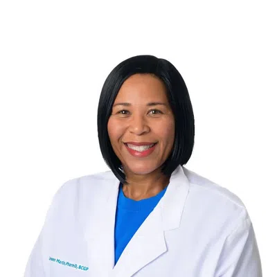 Smiling female healthcare professional in white Evara Health lab coat with blue shirt on white background