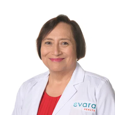 Confident female healthcare professional wearing white lab coat with Evara Health logo against white background