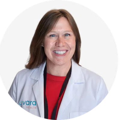 Smiling female healthcare professional in white lab coat with Evora Health logo on a white background