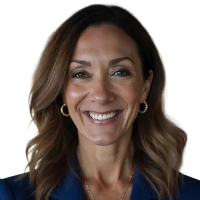 Confident businesswoman in blue blazer smiling with arms crossed in a modern office setting with blurred background.