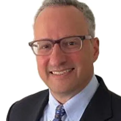 Professional middle-aged man wearing glasses and a suit smiling against a white background