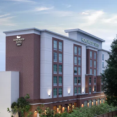 Modern Homewood Suites hotel building with brick and white facade under a clear sky at dusk.