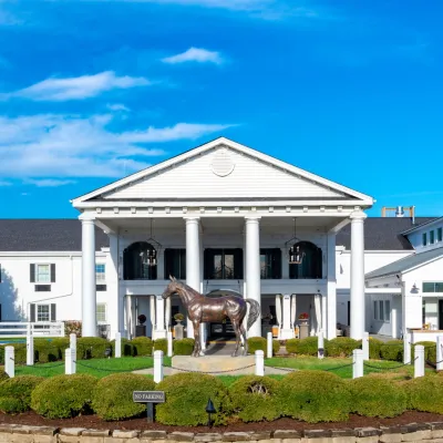 a white house with a horse statue in front of it