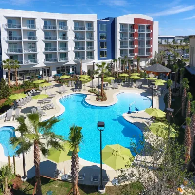 a pool with palm trees and buildings