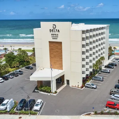 a building with cars parked in front of it by the ocean