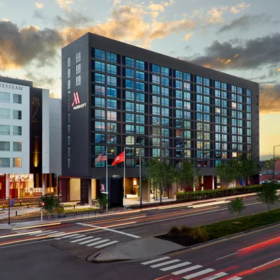 The Tennessean and Marriott hotel buildings at sunset with light trails on a busy city street intersection.