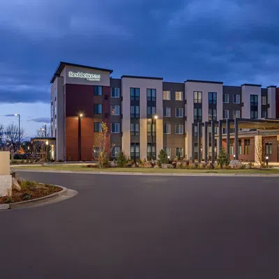 Modern Residence Inn hotel exterior at dusk with illuminated entrance and landscaped surroundings