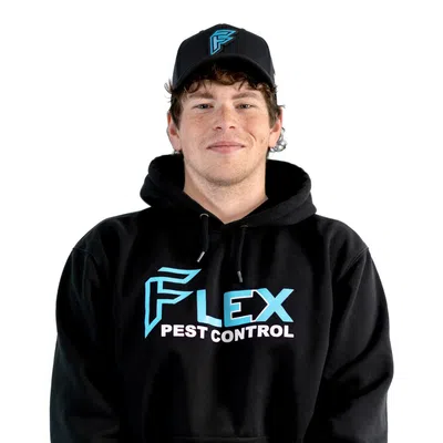 Young man wearing black Flex Pest Control hoodie and matching cap, standing with hands clasped, white background