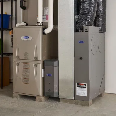 A modern furnace and air conditioning unit in a clean garage space with organized storage shelves.