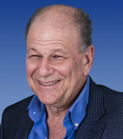 a man smiling with a blue shirt