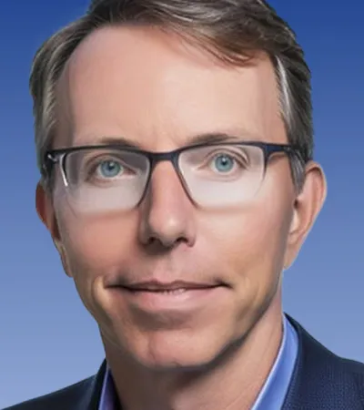 Professional middle-aged man with glasses, blue eyes, and light brown hair wearing a blue suit and shirt.